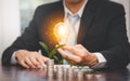 Businessman hand holding light bulb on coins stack on the wooden table , Saving ideas and investment budget, Creative ideas concep Royalty Free Stock Photo