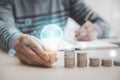 Businessman hand holding light bulb on coins stack on the wooden table , Saving ideas and investment budget, Creative ideas concep Royalty Free Stock Photo