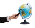 Businessman hand holding magnifier over globe Royalty Free Stock Photo