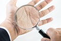 Businessman hand holding magnifying glass on palm. Royalty Free Stock Photo