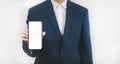 Businessman hand holding mobile white blank screen, Mock up cell mobile smart phone  in suit holds mobile phone with blank white s Royalty Free Stock Photo