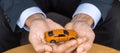 Businessman hand holding orange car toy on table. Financial, money, refinance and Car insurance concept Royalty Free Stock Photo