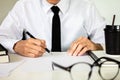 Businessman hand holding a pen writing notebook working on table at the office Royalty Free Stock Photo