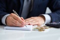 Businessman hand holding a pen writing on notepad