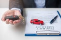 Businessman hand holding remote keyless with car toy, pen and contract document. buy and sale, insurance, rental and contract