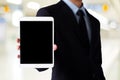 Businessman hand holding tablet with blank on screen display over blur background, business people and technology display montage Royalty Free Stock Photo