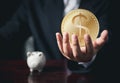 Businessman Hand holding us coin. Digital Money and Bitcoin Concept. Cryptocurrency golden coin, stock exchange graph background. Royalty Free Stock Photo