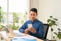 Businessman hand holding using texting cell phone at his working space Royalty Free Stock Photo