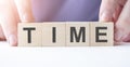 Businessman hand holding wooden cube block with time business word on table background Royalty Free Stock Photo