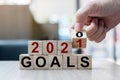 Businessman hand holding wooden cube with flip over block 2020 to 2021 GOALS word on table background. Resolution, strategy, Royalty Free Stock Photo