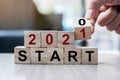 Businessman hand holding wooden cube with flip over block 2020 to 2021 START word on table background. Resolution, strategy, Royalty Free Stock Photo