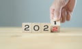 Businessman hand holding wooden cube with flip over block years 2021 to 2022 Plans word on table background. Resolution, strategy, Royalty Free Stock Photo