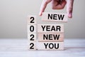 Businessman hand holding wooden cube with text 2022 New Year New You on table background. Resolution, strategy, solution, goal, Royalty Free Stock Photo