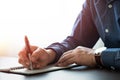 Businessman hand holding writing pen memo into notebook paper on table desk office. Royalty Free Stock Photo