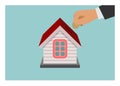 Businessman hand inserting coin to the home piggy bank. Simple flat illustration.