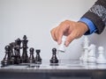 Businessman hand moving chess piece on board with white background, challenges planning business strategy to success concept Royalty Free Stock Photo