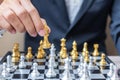 Businessman hand moving gold Chess King figure and Checkmate enermy or opponent during chessboard competition. Strategy, Success,