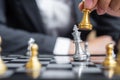 Businessman hand moving gold Chess King figure and Checkmate enermy or opponent during chessboard competition. Strategy, Success,