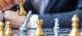 Businessman hand moving gold Chess King figure and Checkmate enermy or opponent during chessboard competition. Strategy, Success,