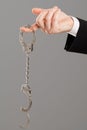 Businessman hand with opened handcuffs
