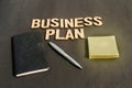 Businessman hand placing a pen and notebook in front of Word Business Plan made of wooden blocks of Alphabet letters. High Angle Royalty Free Stock Photo