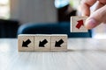 Businessman hand placing or pulling Red arrow wooden block on table background. Business, Think Different, Unique, New Way, Change