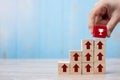 Businessman hand placing or pulling Red block with Trophy and growth up arrow on table background. Business Growth, Improvement, Royalty Free Stock Photo