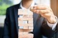 Businessman hand placing or pulling wooden block on the tower. Business planning, Risk Management Royalty Free Stock Photo