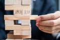 Businessman hand placing or pulling wooden block on the tower. Business planning, Risk Management Royalty Free Stock Photo