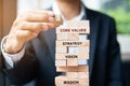 Businessman hand placing or pulling wooden block on the tower. Business planning, Risk Management, Solution, Mission, Vision, Core Royalty Free Stock Photo