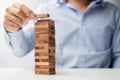 Businessman hand placing or pulling wooden block on the tower. Business planning, Risk Management, Solution and strategy Concepts Royalty Free Stock Photo