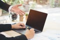 Businessman hand pointing on black blank screen laptop to explanation and takes note on business document in office while meeting. Royalty Free Stock Photo