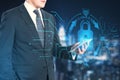 Businessman hand pointing at tablet with abstract glowing blue padlock hologram on blurry night city background. Internet, Royalty Free Stock Photo