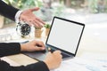 Businessman hand pointing on white blank screen laptop to explanation and takes note on business document in office while meeting. Royalty Free Stock Photo