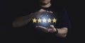 Businessman hand protect five yellow stars with blue glowing light , Customer evaluation and client satisfaction for product and