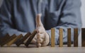 Businessman hand protect and stop standing wooden bar from domino falling wooden bar for crisis risk management and analysis Royalty Free Stock Photo