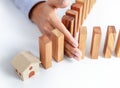 Businessman hand protect wooden home toy block from danger and fall Royalty Free Stock Photo