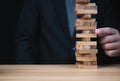 Businessman hand of businessman pulling out or placing wood block on the tower with copyspace. Business risk, strategy and planing Royalty Free Stock Photo