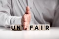Businessman hand puts away the first two letters from the word unfair and transforms it into fair. Justice and fairness in