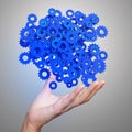 Businessman hand showing blue gears cogs