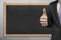 Businessman hand showing thumb up with blank blackboard Royalty Free Stock Photo