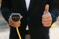 Businessman hand showing thumbs up holding power type 2 ccs cable supply plugged at electric car charging station. Man Royalty Free Stock Photo