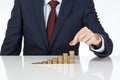 Businessman hand stacking one euro coins into increasing columns