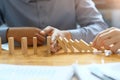 Businessman hand stopping the domino effect. executive and risk Royalty Free Stock Photo