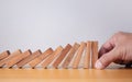 Businessman hand stopping falling blocks on table, stopping the domino effect concept for business solution, strategy and Royalty Free Stock Photo