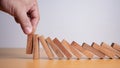 Businessman hand stopping falling blocks on table, stopping the domino effect concept for business solution, strategy and Royalty Free Stock Photo