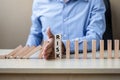 Businessman hand Stopping Falling wooden Blocks or Dominoes. Business, Risk Management, Solution, Insurance and strategy Concepts Royalty Free Stock Photo