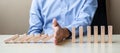 Businessman hand Stopping Falling wooden Blocks or Dominoes. Business, Risk Management, Solution, Insurance and strategy Concepts Royalty Free Stock Photo