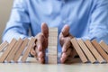 Businessman hand Stopping Falling wooden Blocks or Dominoes. Business, Risk Management, Solution, Insurance and strategy Concepts