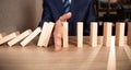 Businessman hand Stopping Falling wooden blocks. Strategy and successful intervention concept for business Royalty Free Stock Photo